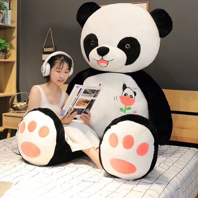 Black and white giant panda hugging panda plush toy