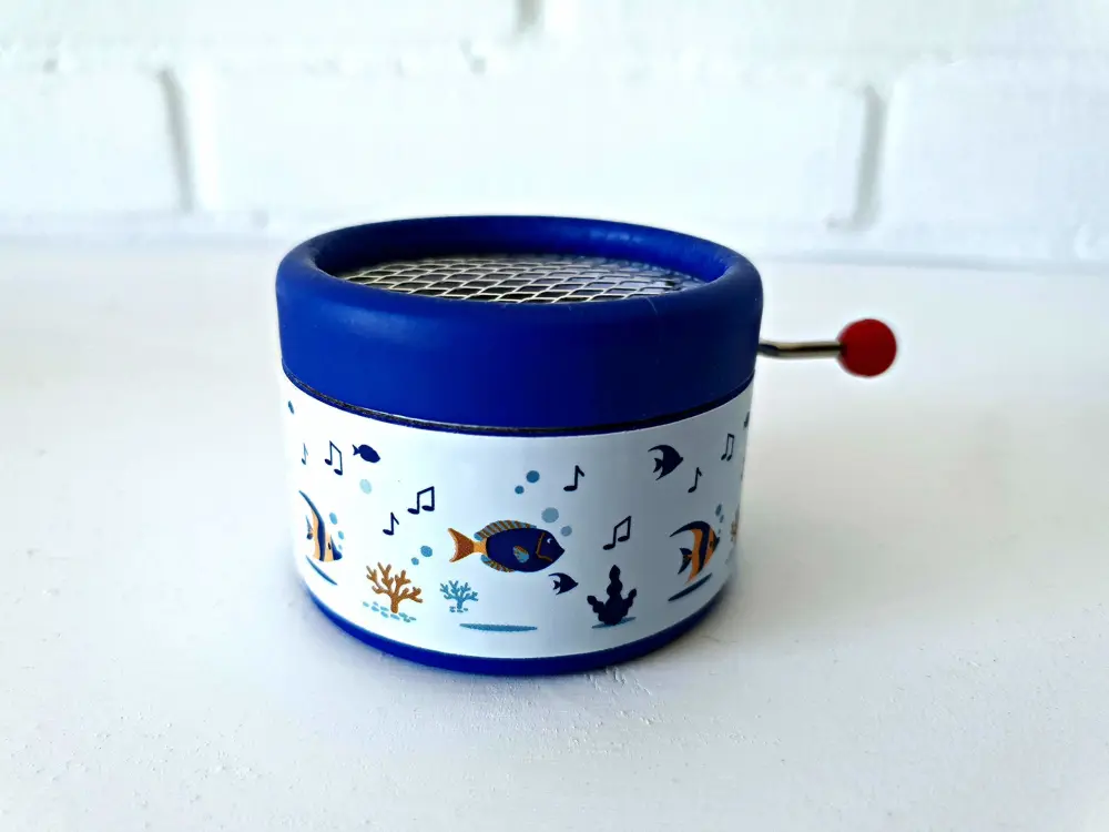 Blue music box decorated with sea patterns and the song Hey Jude on a hand crank