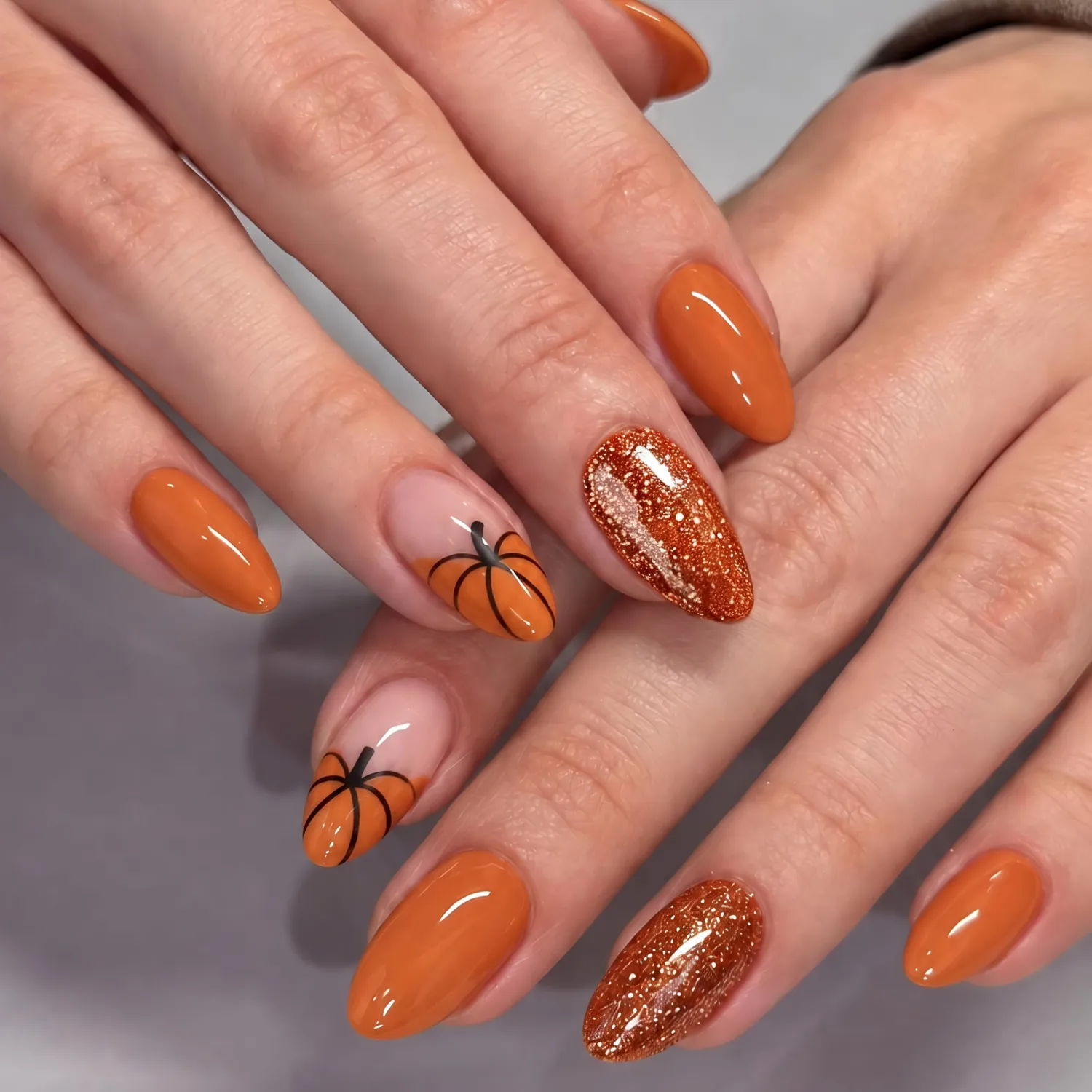 UNA GELLA Halloween Press On Nails Short Almond, 32Pcs Pumpkin Fake Nails Soft Gel Nail Tips Almond Shape in 16 Sizes with Semi Glue and Jelly Tabs, Orange Glitter Finish for Party Fall Manicures